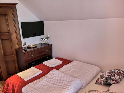 a bedroom with a bed and a dresser with a television at Villa Watamu in Trzęsacz