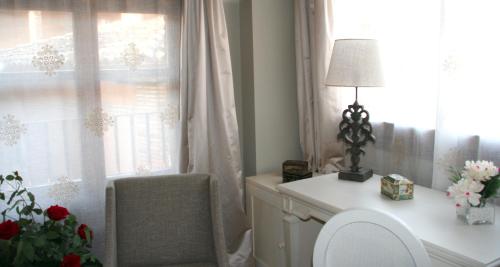 a desk with a lamp and a chair next to a window at Hotel Castillo de Alquézar in Alquézar