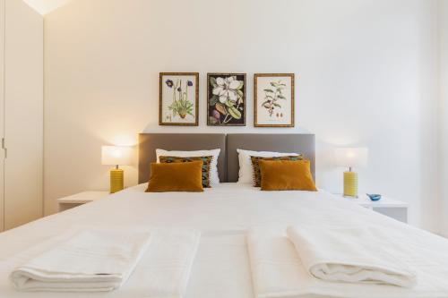 a bedroom with a large white bed with orange pillows at Trendy & Classic 2bedroom apartment in Lisbon
