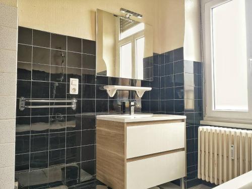 une salle de bain avec un lavabo et un miroir dans l'établissement Le XI - Suite Colmar Gare, à Colmar