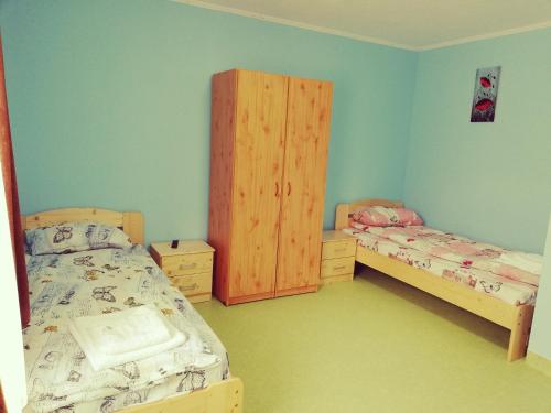 a bedroom with two beds and a wooden cabinet at Cazare tudor&abril in Cojocna