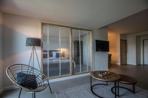 a living room with a chair and a table and a window at ParaLodge in Saint-Vincent-les-Forts