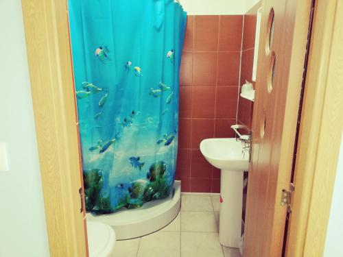 a bathroom with an aquarium shower curtain and a sink at Cazare tudor&abril in Cojocna