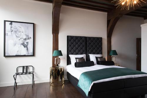 a bedroom with a large bed and a large window at Boutique Hotel Steenhof Suites in Leiden
