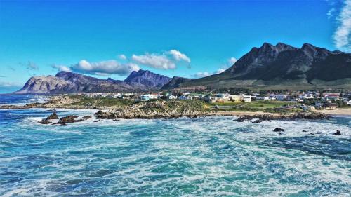 uitzicht op een strand met bergen op de achtergrond bij 36 Df Strauss Street in Kleinmond