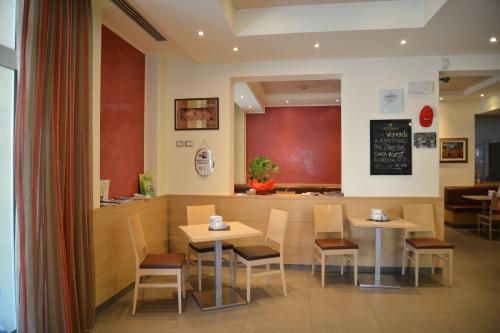 a restaurant with two tables and chairs and a counter at Hotel Bel Sit in Comano Terme