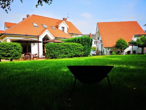 a black chair in the grass in front of a house at Villa Watamu in Trzęsacz
