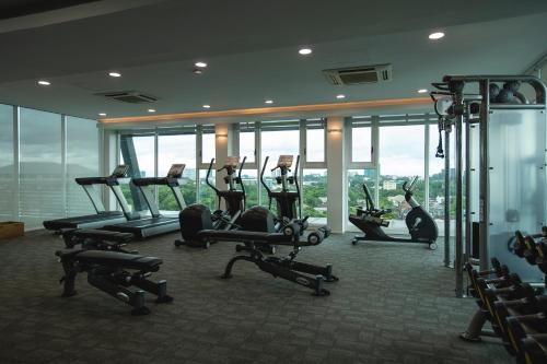 a gym with cardio equipment in a building with windows at Residence26 in Yangon