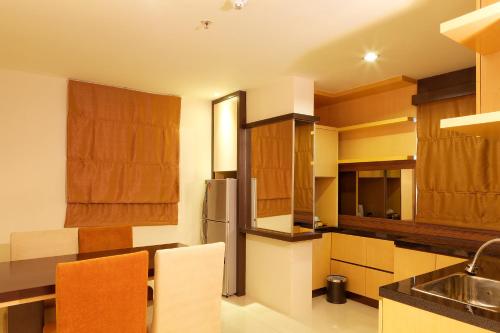 a kitchen with wooden cabinets and a sink and a refrigerator at Nagoya Mansion Hotel and Residence in Nagoya