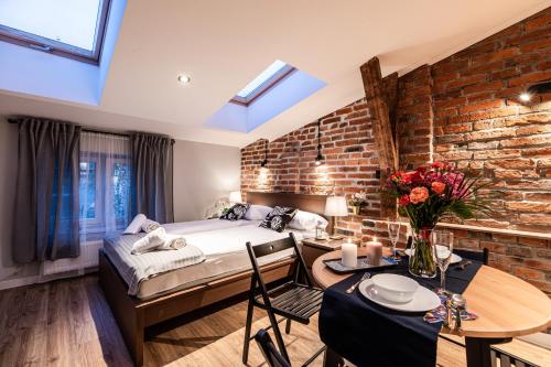a bedroom with a bed and a brick wall at Lubomirskiego 23 Residence - great location, 10 min to Main Square by foot, right next to Main Rail and Bus Station in Krakow