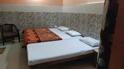 two beds in a small room with a chair at Vidya Guest House in Katra