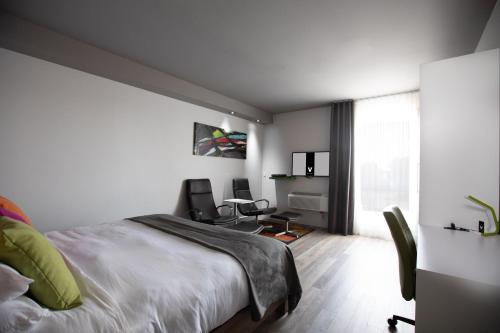 a bedroom with a bed and a desk and chairs at Hotel V in Gatineau