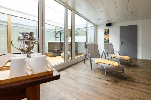 een grote kamer met een tafel en stoelen en glazen wanden bij Partner Hotel AG Zofingen in Zofingen