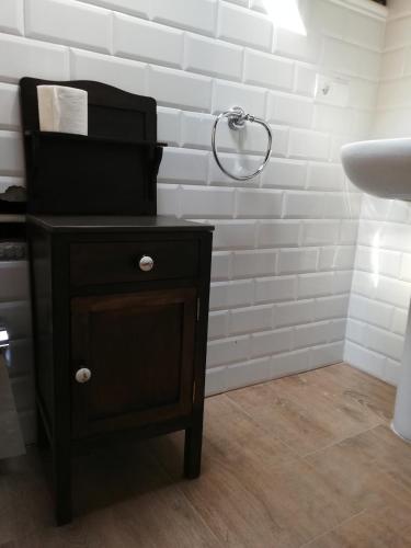 a bathroom with a black nightstand and a sink at Albergue la Medina de Camponaraya in Camponaraya