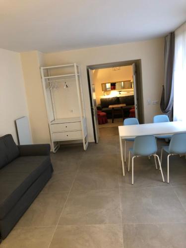a living room with a couch and a table and chairs at Stylische Cityapartments Benedikt in Klagenfurt