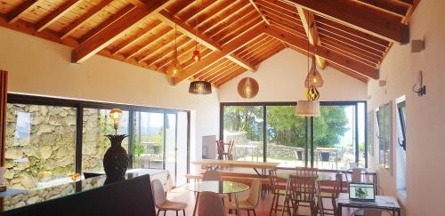 una habitación con mesas y sillas y un gato en la pared en Caparica Azores Ecolodge, en Biscoitos