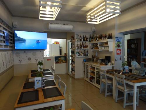 a restaurant with tables and a tv on the wall at Aris Studios in Hersonissos