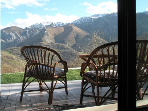 2 sillas en un porche con vistas a las montañas en La Senda del Casaño en Canales