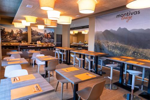 ein Restaurant mit Tischen und Stühlen und einem großen Wandbild in der Unterkunft Montivas Lodge in Livigno