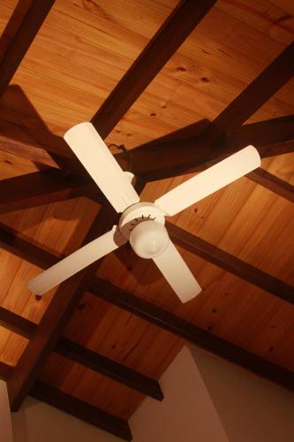 Een plafondventilator hangt aan een houten plafond. bij Acuarela in Villa Gesell