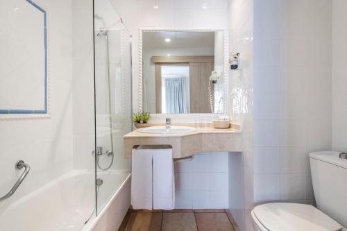 a bathroom with a sink and a tub and a toilet at Intelier Bonaire in Benicàssim