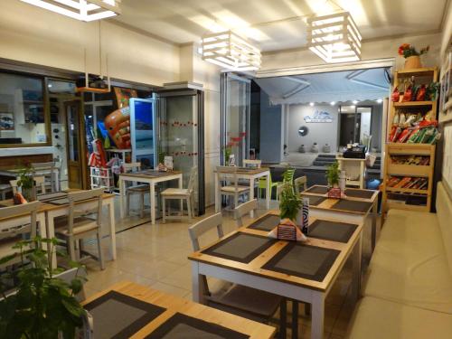 a restaurant with tables and chairs in a room at Aris Studios in Hersonissos