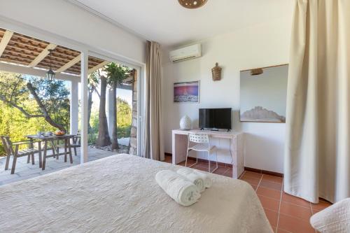 a bedroom with a bed and a television and a patio at Tenuta Terenzano in Torre San Giovanni Ugento
