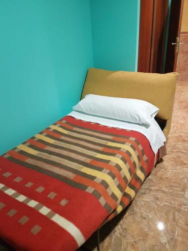 a bed with a colorful blanket on top of it at Camping-Hotel Los Molinos in Ruidera