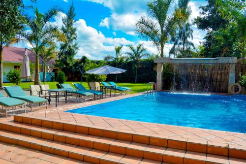 a swimming pool with chairs and a fountain at Tulia Boutique Hotel & Spa in Arusha
