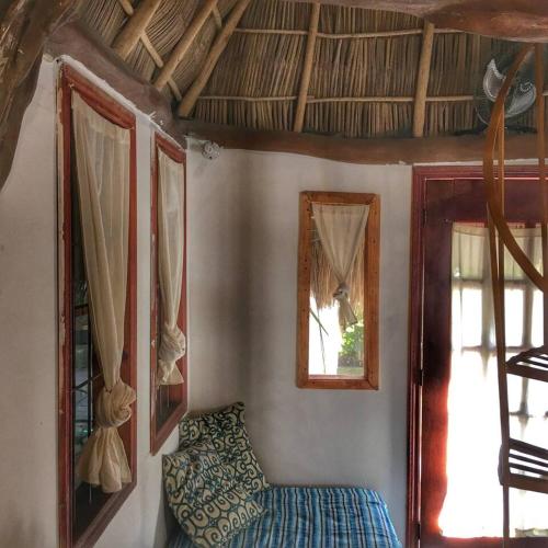 a room with a bed and two windows and a chair at Palapa Chili # in Sayulita