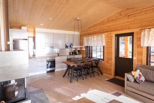 a kitchen and living room with a table and chairs at Villa Vahtivuori in Rantasalmi