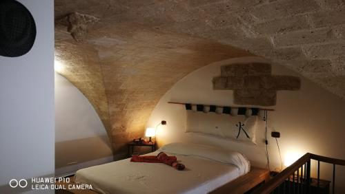 1 dormitorio con 1 cama con pared de piedra en VersoSud cave, en Bari