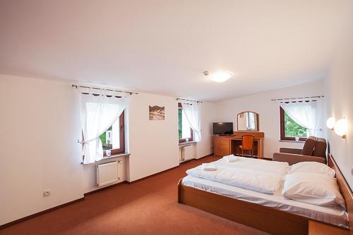 a bedroom with a bed and a couch and windows at Willa Agnieszki in Jelenia Góra-Jagniątków