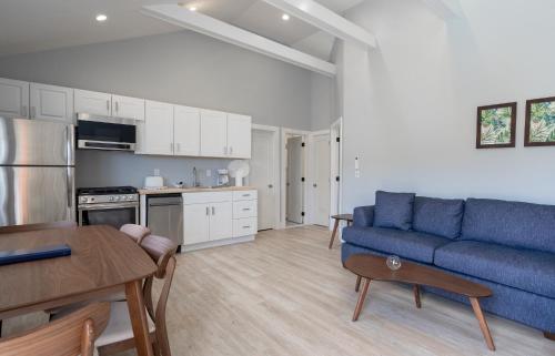 a living room with a blue couch and a kitchen at A Wave Inn - Montauk in Montauk