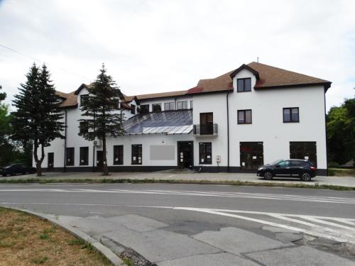 a white house with a car parked in front of it at Pan Tadeusz in Zwierzyniec