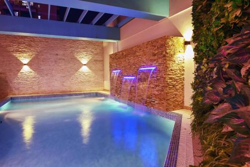 a swimming pool in a room with a brick wall at Meshal Hotel in Manama