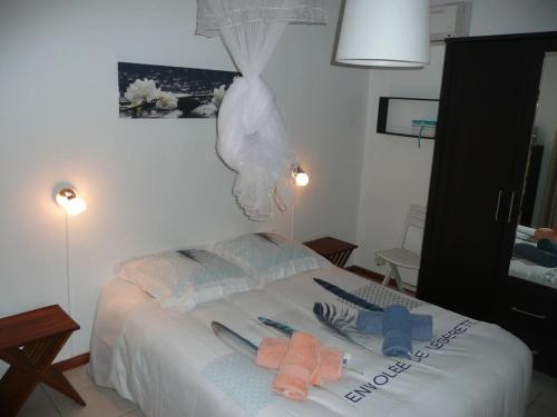 - une chambre avec un lit et des serviettes dans l'établissement BUNGALOW DU VOYAGEUR, au Marin