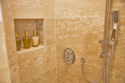 a shower with three bottles on a shelf at Piazza Posta Dimora di Charme in Procida