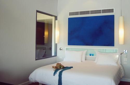 a teddy bear sitting on top of a bed at The Houben - Adult Only in Ko Lanta