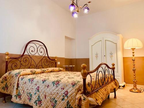 a bedroom with a bed with a comforter and a lamp at Agriturismo Poggio Tondo in Casa Agresti