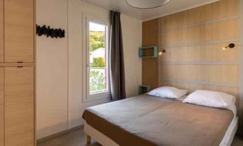 Saint-Martin-dʼArrossaDomaine Chalets Larlapean的带床和窗户的卧室
