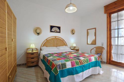 a bedroom with a bed with a colorful bedspread at Villino Melina in Santa Maria al Bagno