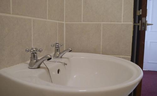 a white sink with two faucets in a bathroom at Union Hotel in Penzance