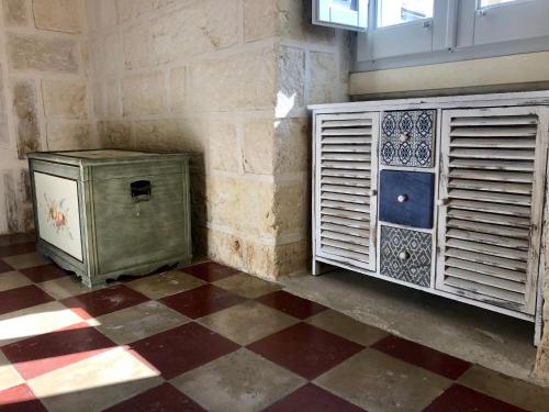 a room with a cabinet and a checkered floor at La `Ssuta in Poggiardo
