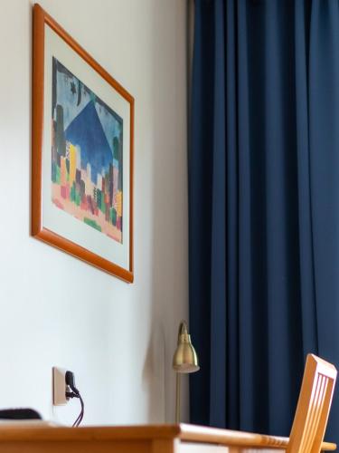 a desk with a lamp and a blue curtain at Hotel Jahtihovi in Kuopio