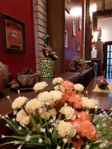a room with a table with flowers on it at Pousada Canoa Caiçara Ilhabela in Ilhabela