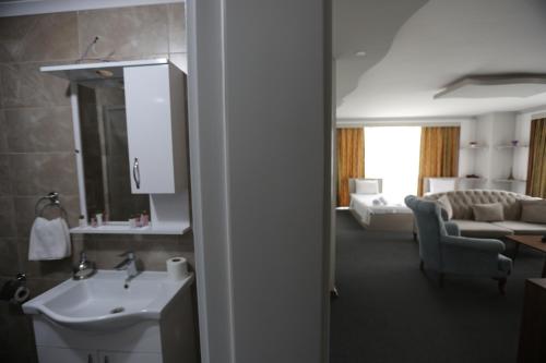 a bathroom with a sink and a living room at TEVETOGLU HOTEL in Istanbul