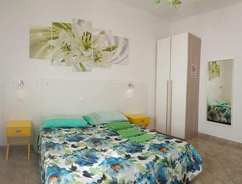ボローニャにあるベッド アンド ブレックファースト コルティチェッラ 24のベッドルーム1室(花の絵が飾られたベッド1台付)