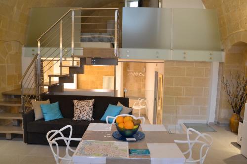 uma sala de estar com um sofá e uma mesa com uma taça de fruta em Vivere nei Sassi em Matera