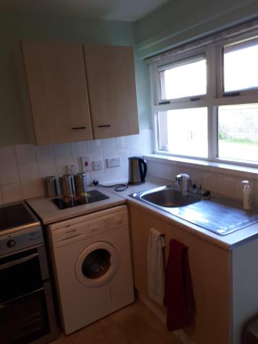 a kitchen with a washing machine and a sink at 3 MacNean Park in Belcoo